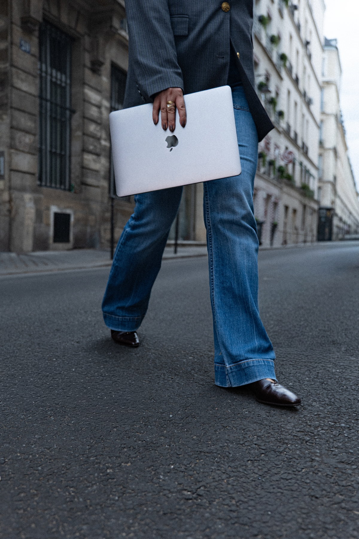 Nina Xu crossing a Paris street with a laptop under her arm