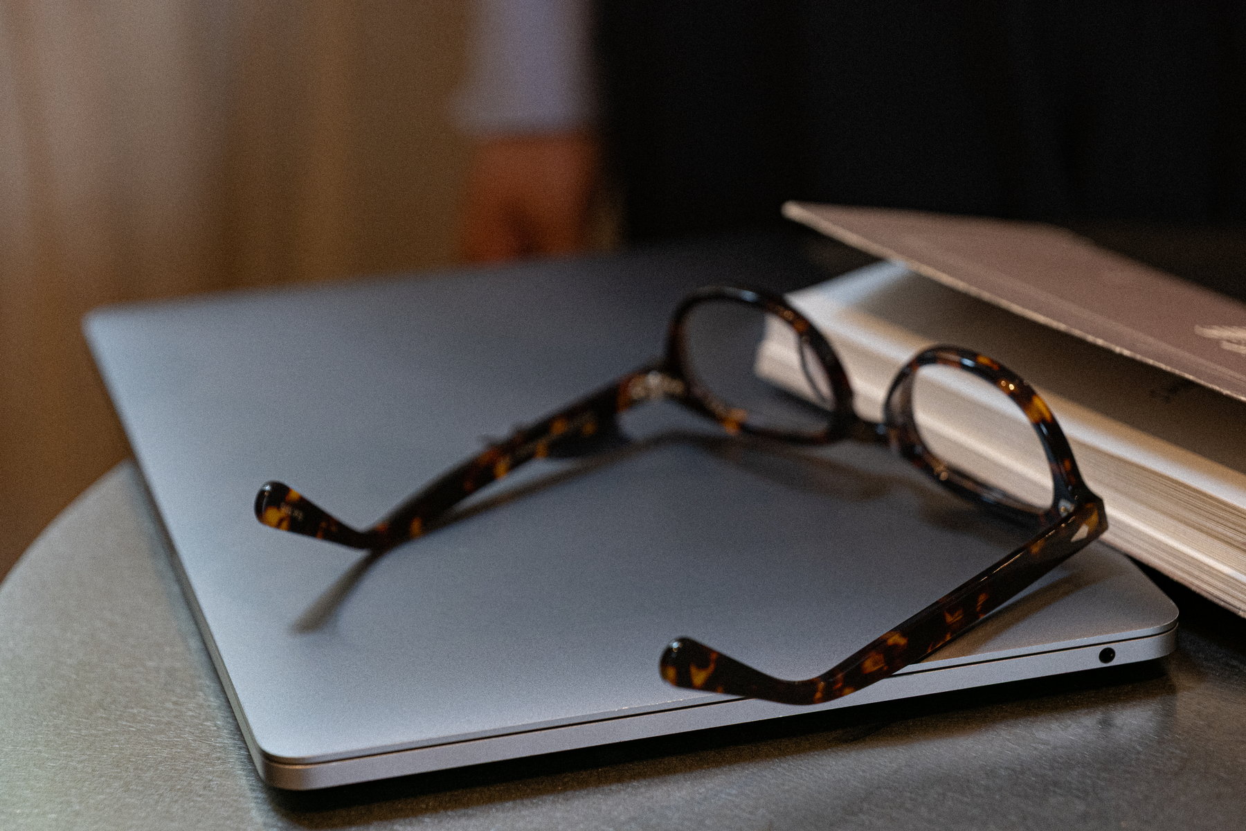 Reading glasses resting on a closed laptop